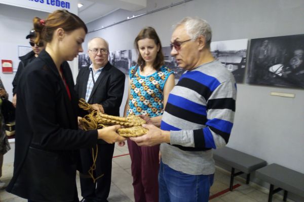 Научный сотрудник музея демонстрирует экспонаты - лапти